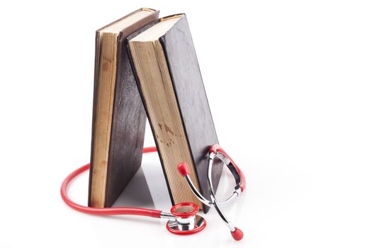 Two Books with Red Stethoscope on White Background With Reflection