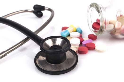 Black Stethoscope with jar of pills Close-up Isolated On White Background