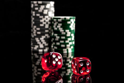 Dice and chips isolated on black background with reflexion