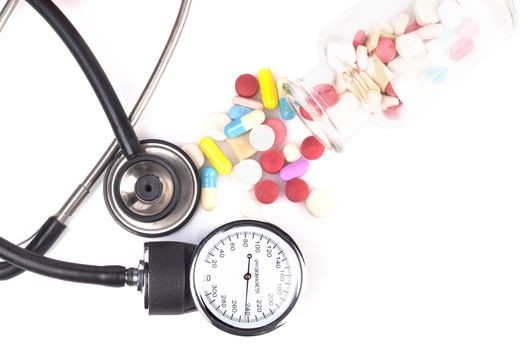 colored pills with black stethoscope isolated on white background