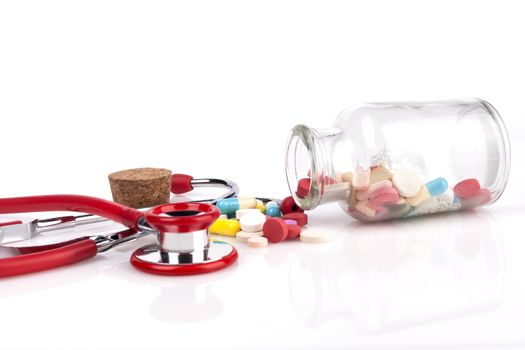 Red Stethoscope with jar of pills Close-up Isolated On White Background