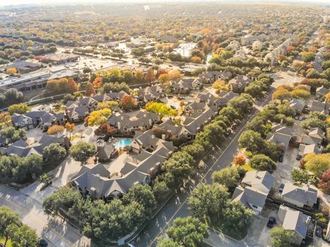 Aerial view riverside residential subdivision in fall season with colorful autumn leaves near Dallas, Texas. Urban sprawl of residential houses and apartment building complex