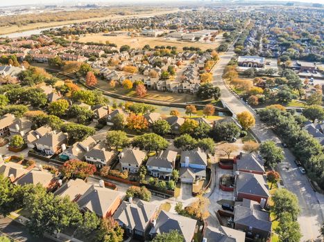 Aerial view riverside residential subdivision in fall season with colorful autumn leaves near Dallas, Texas. Urban sprawl of residential houses and apartment building complex