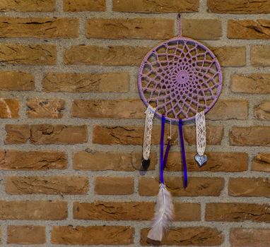 beautiful hand made dream catcher hanging on a brick wall, home decorations, spiritual background