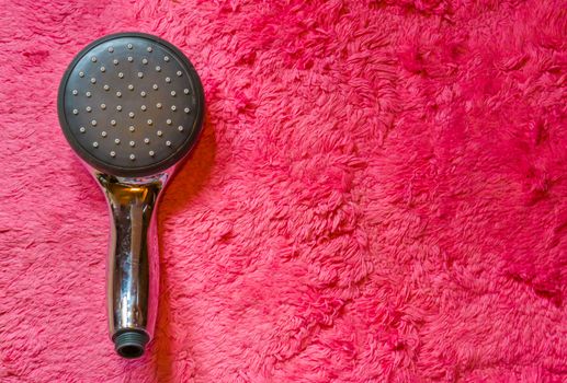 eco friendly modern shower head isolated on a soft pink carpet background