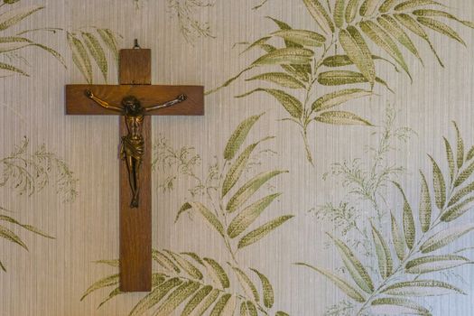 wooden cross with a crucified jesus sculpture hanging on a wall, religious background