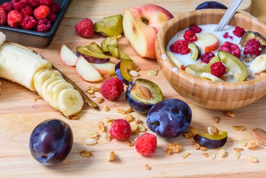 Muesli with sweet berries, fruits and milk - tasty and healthy breakfast. Scattered ingredients and slices of fruits.