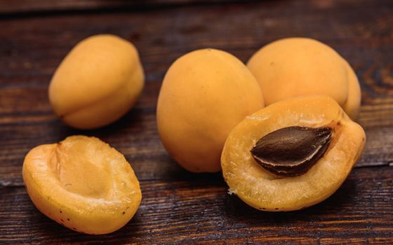 two half of apricot with pip on dark wooden background