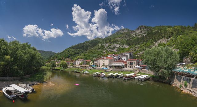 Skadar lake, Montenegro - 07.15.2018.  Panoramic view of the Old Bridge over Crnojevica river, Rijeka Crnojevica, and the tourist area near the bridge, Rijeka Crnojevica.