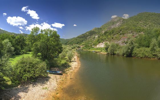 Skadar lake, Montenegro - 07.15.2018.  Panoramic view of the Old Bridge over Crnojevica river, Rijeka Crnojevica, and the tourist area near the bridge, Rijeka Crnojevica.