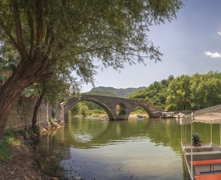 Skadar lake, Montenegro - 07.15.2018.  Panoramic view of the Old Bridge over Crnojevica river, Rijeka Crnojevica, and the tourist area near the bridge, Rijeka Crnojevica.