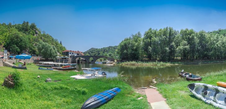 Skadar lake, Montenegro - 07.15.2018.  Panoramic view of the Old Bridge over Crnojevica river, Rijeka Crnojevica, and the tourist area near the bridge, Rijeka Crnojevica.