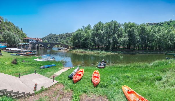 Skadar lake, Montenegro - 07.15.2018.  Panoramic view of the Old Bridge over Crnojevica river, Rijeka Crnojevica, and the tourist area near the bridge, Rijeka Crnojevica.