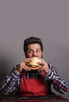 Young man biting fresh tasty hamburger