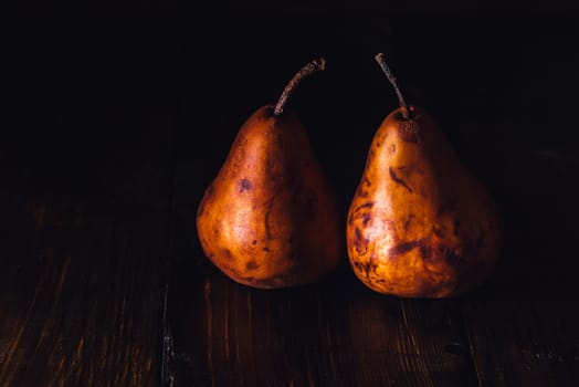 Two Golden Pears on Dark Wooden Table