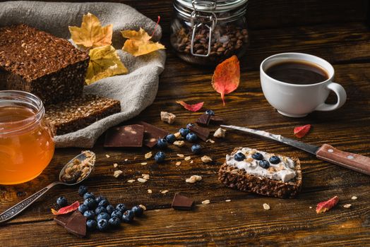 Toast with Blueberries and Coffee for Healthy Breakfast on Wooden Surface.