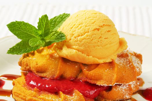 Spritz butter cookies with raspberry sauce and scoop of yellow ice cream