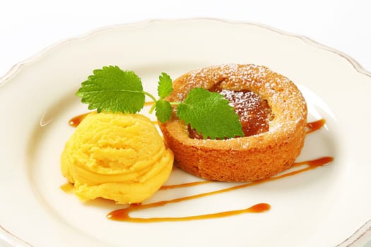 Small apple filled tart and scoop of yellow ice cream