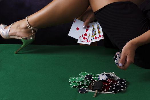 Sexy Girl legs on table in black dress with casino chips and cards