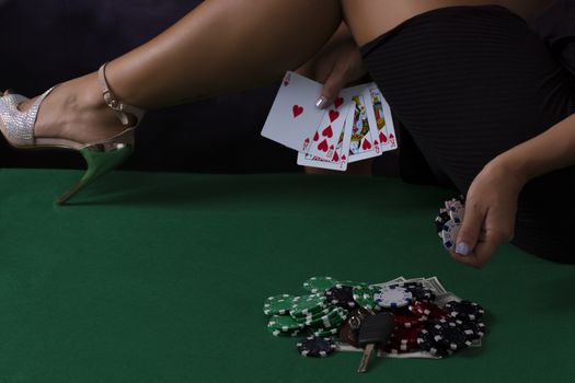 Sexy Girl legs on table in black dress with casino chips and cards