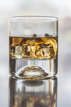 A glass of alcohol on table with reflection