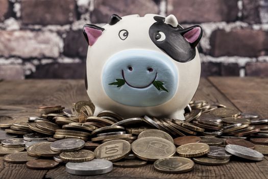 Piggy baknd on wood table and brick background