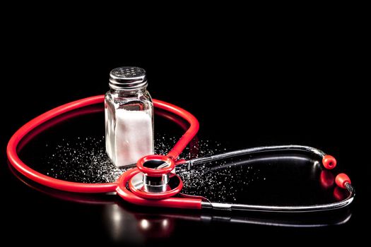 Medical instrument and salt isolated on black background with reflection