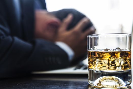 Man having problems, with a glass of alcohol near him