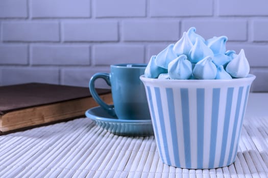 Blue sweets and cup and white brick background