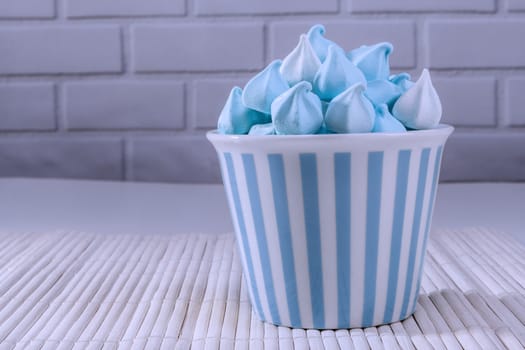 Blue sweets in a cup and white brick background
