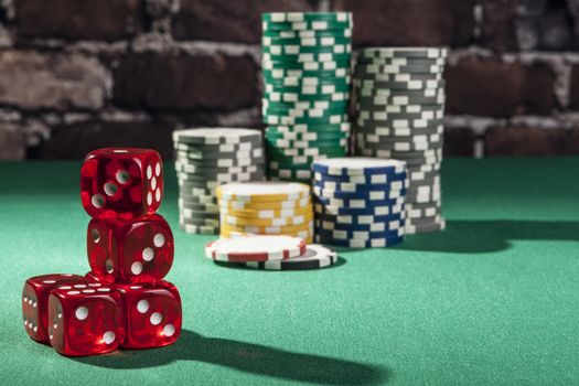 Red dice and chips on green table with shadow