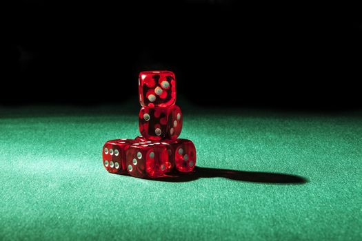 Red dice on green and black background