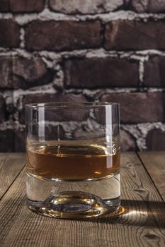 Glass of alcohol on brown wood table