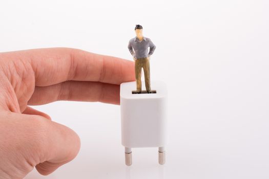 Hand holding a human figure on a white adapter