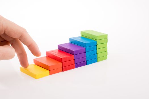 Hand playing with colored domino on white background