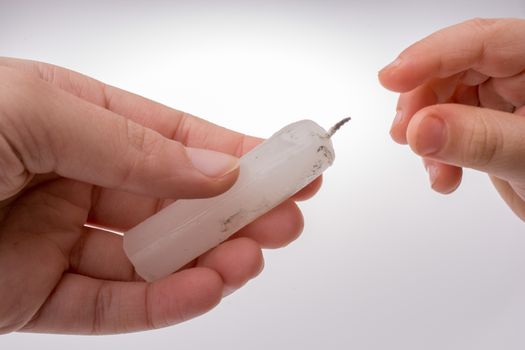 White candle stick in hand on a white background