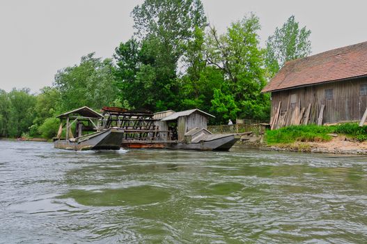 Unique traditional boat mill on a river, Mura river in Slovenia with famous landmark, rural travel concept, rare heritage of Europe