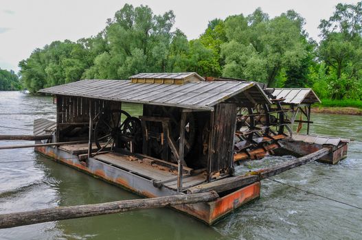 Close up of unique traditional mill on boats a river, Mura river in Slovenia with famous landmark, rural travel concept, rare heritage of Europe