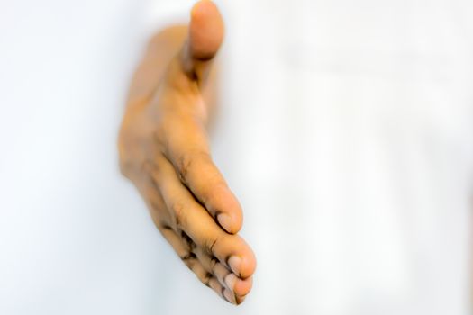 Close up businessmen hands stretched out for handshaking. Businessman or salesman, stretches his hand to conclude a business deal. Partners welcoming after negotiation of contract or agreement complete.