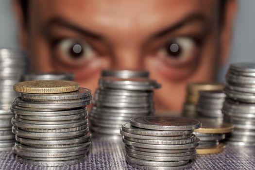 Focus on Coin. A rich greedy elderly man looks at coins. The collector looks at his wealth. An elderly man staring at metal money on the floor.