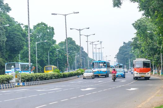 KOLKATA, INDIA, ASIA - 5 MAY 2017: City on a rush hour at daytime. Vehicals are moving forward on a busy city street and cars on road. Urban traffic. Outdoor photography.