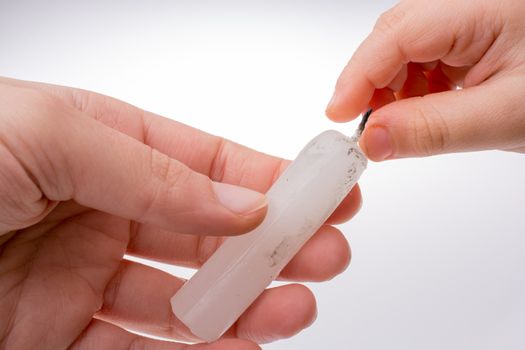 White candle stick in hand on a white background