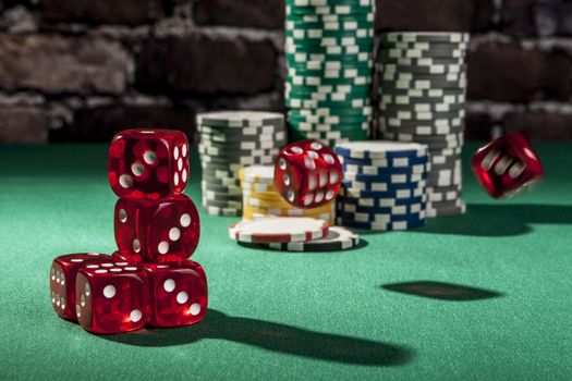 Red dice and chips on green table