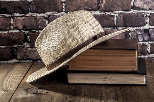 Hat and books on brown wood table
