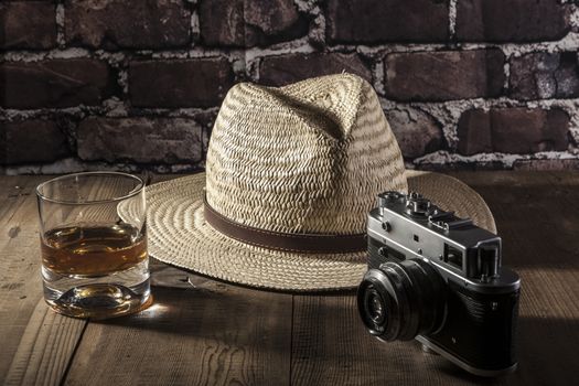 Hat and camera on brown wood table