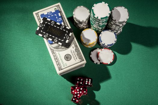 Money, dice and chips on green table