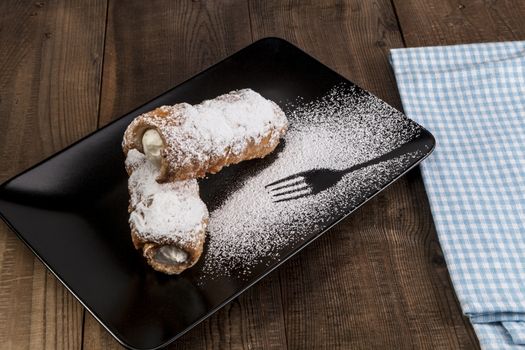 Sweets on black plate on wood table