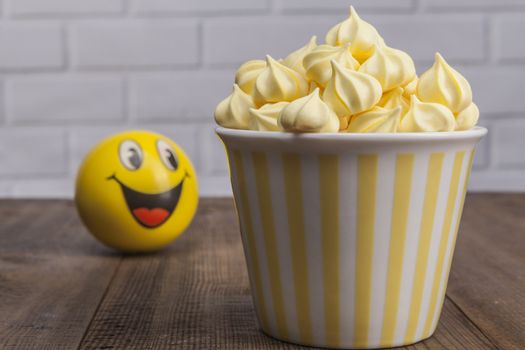 Yellow sweets on wood table and white brick background