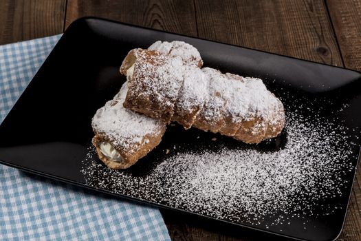 Sweets on black plate on wood table