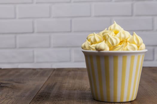Yellow Sweets on wood table and white brick background